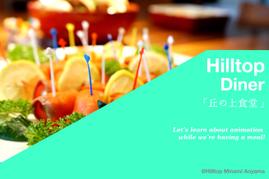 カラフルなピックが刺さったフルーツやレモンが並んだ料理を前景に、「Hilltop Diner 丘の上食堂」の文字が入ったミントグリーンのバナー